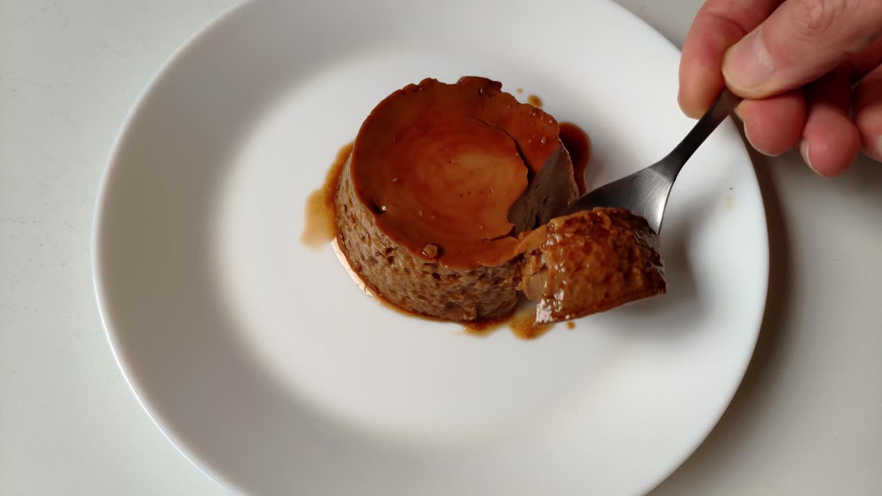 Delicious coffee-flavored flan with a smooth caramel layer on a white plate