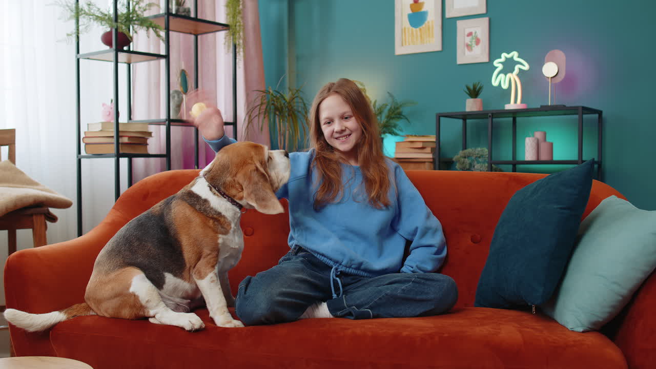 소녀는 카메라를 향해 우호적으로 미소 짓고 손을 흔들며 인사합니다.