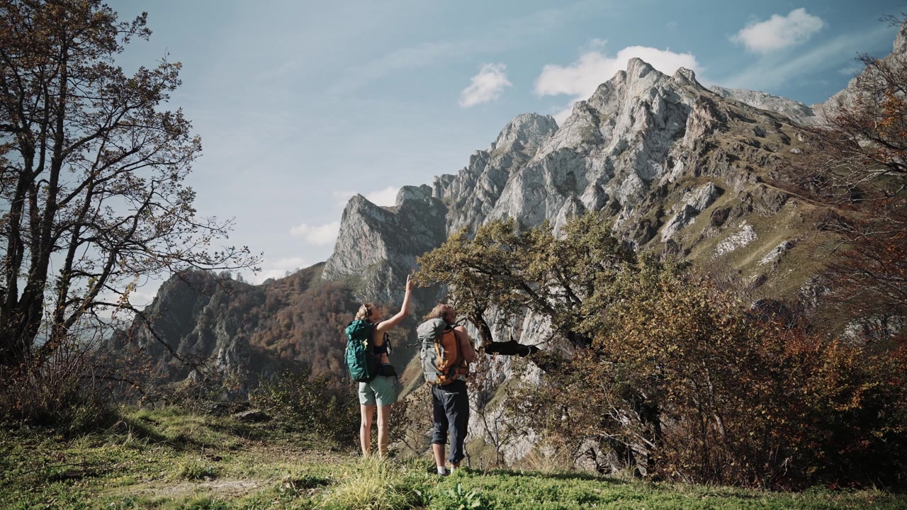Escursionisti pronti a fare un'escursione su un'imponente montagna in Spagna, vista da dietro.