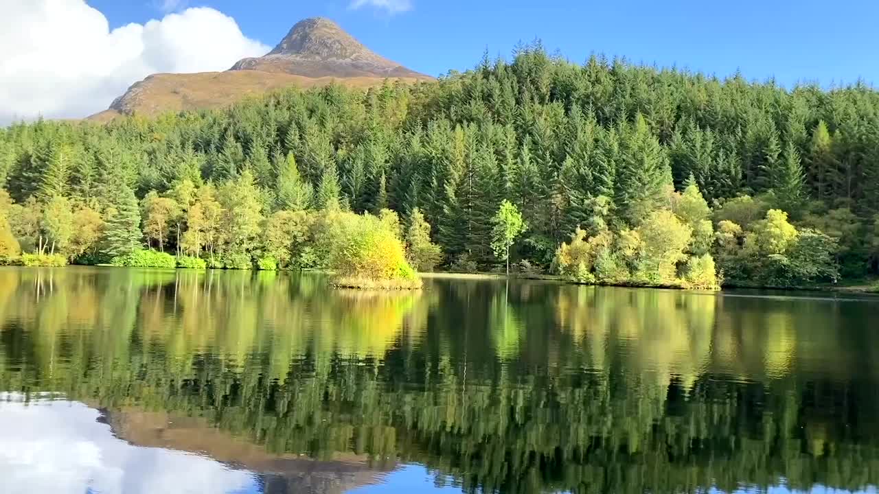 Scenery and reflections of a lake at Glencoe Lochan on a sunny day