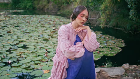 dreamy girl posing lake covered water lilies closeup. fantasy model sitting pond