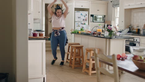 chica adolescente con sobrepeso feliz bailando en la cocina divirtiéndose celebrando el fin de semana realizando movimientos de baile divertidos en casa disfrutando de la celebración del fin de semana