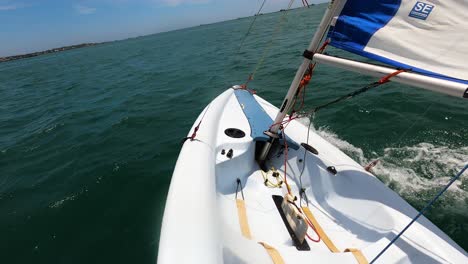 solo sailing dinghy boat in deep ocean water, pov view