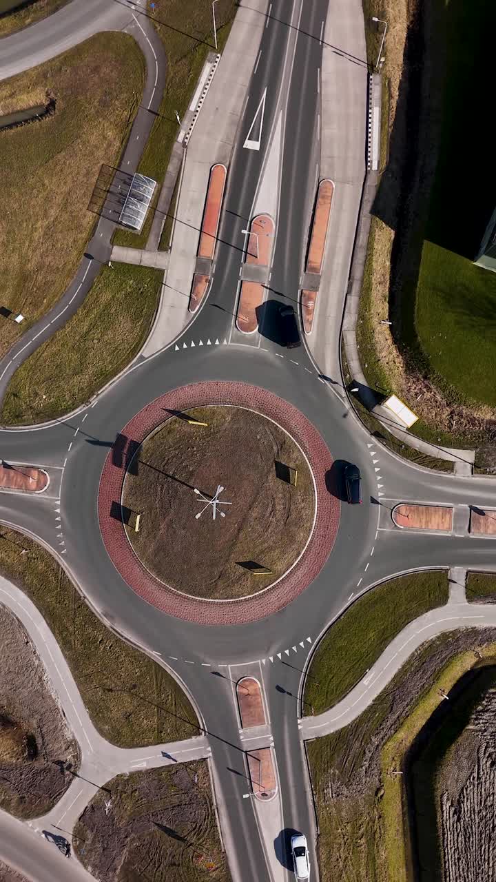 Aerial Top Down View of Cars Driving Through a Roundabout