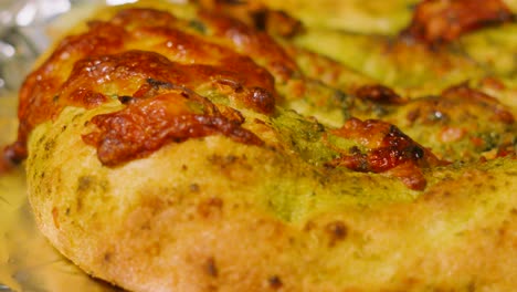 moving shot over freshly baked mozzarella and sun blushed tomato pesto garlic bread. fresh italian side dish food