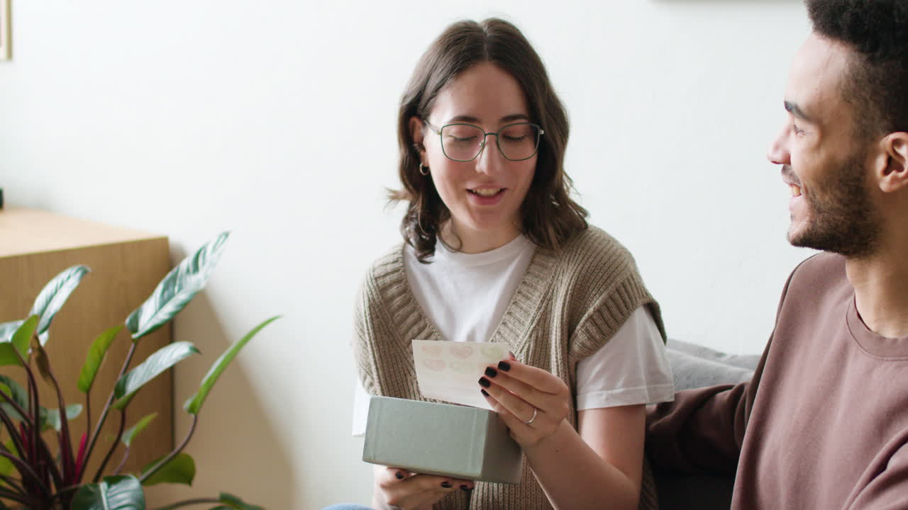 una pareja joven sentada en el sofá.