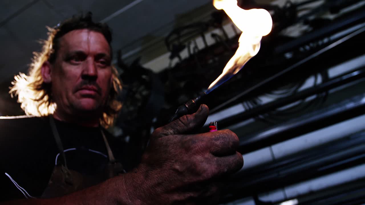 soldador que quema la antorcha de soldadura con un encendedor