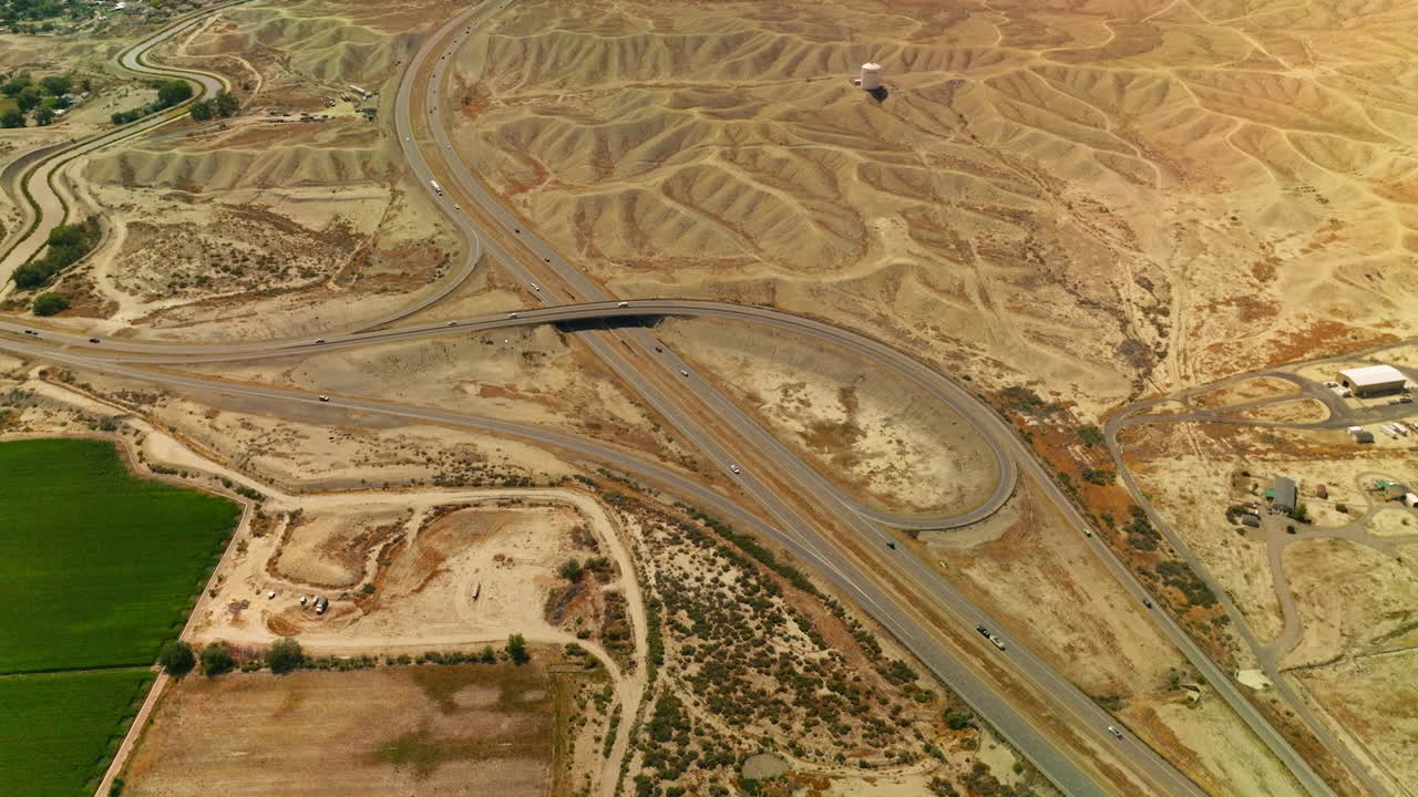 Roads crossing in the desert of Colorado, USA. Cars running fast by the highways among the sandy dunes. Aerial view.