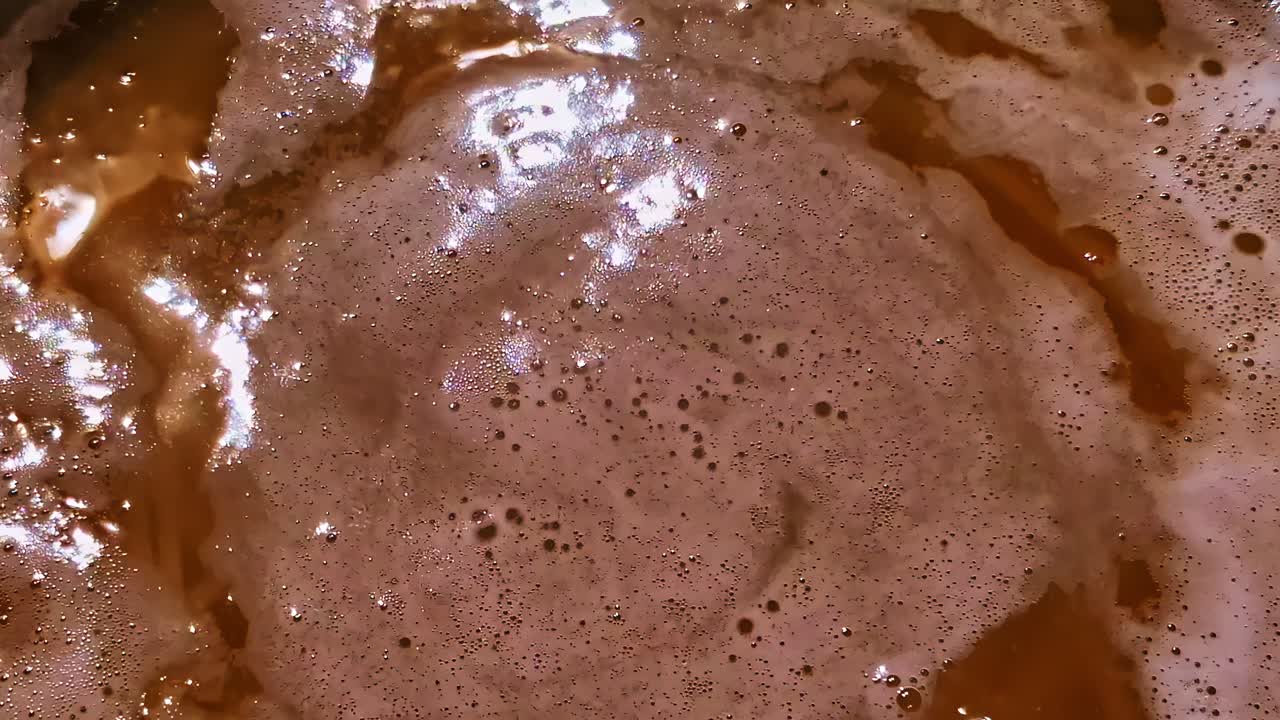 Pasta boiling in bubbling water in metal pot with steam rising while cooking