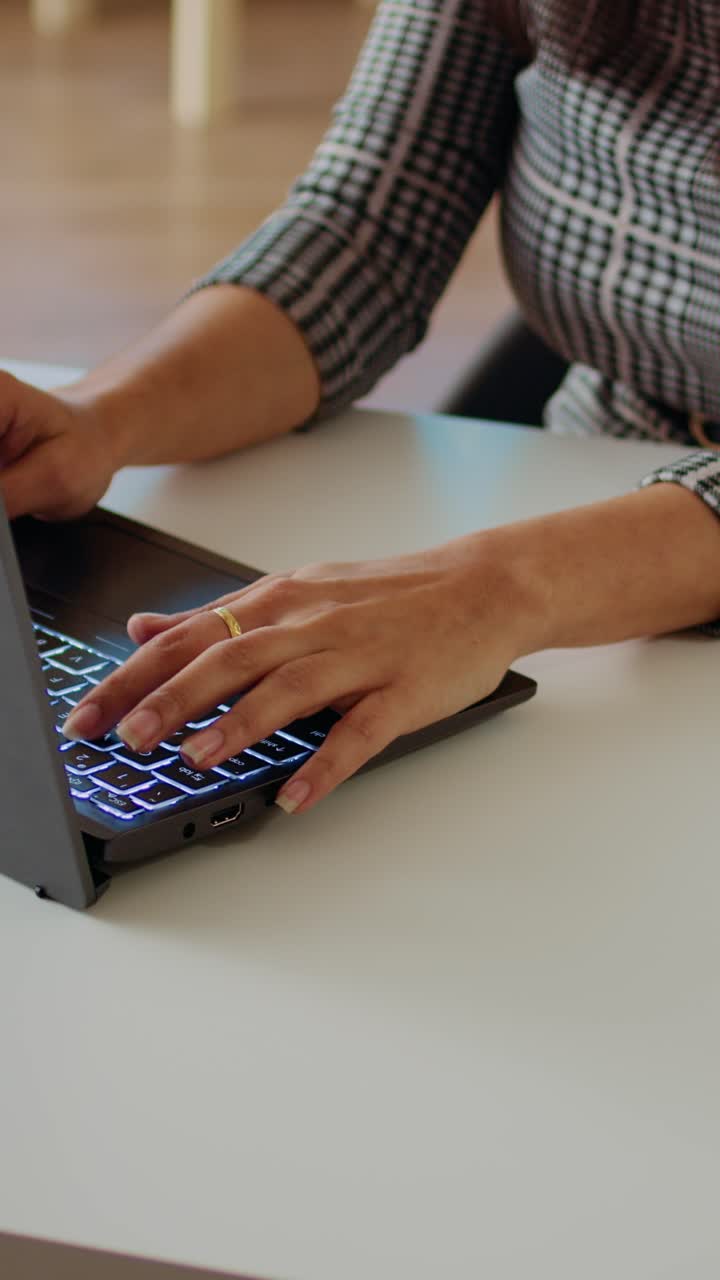 Video verticale di un telelavoratore che scrive e-mail sul portatile e le invia ai partner commerciali