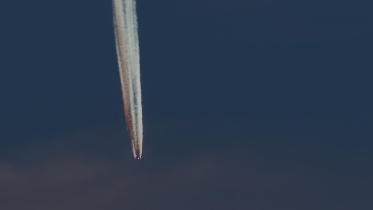 самолет с ярким контрайлом в голубом небе