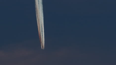 avión con contrails vívidos en el cielo azul