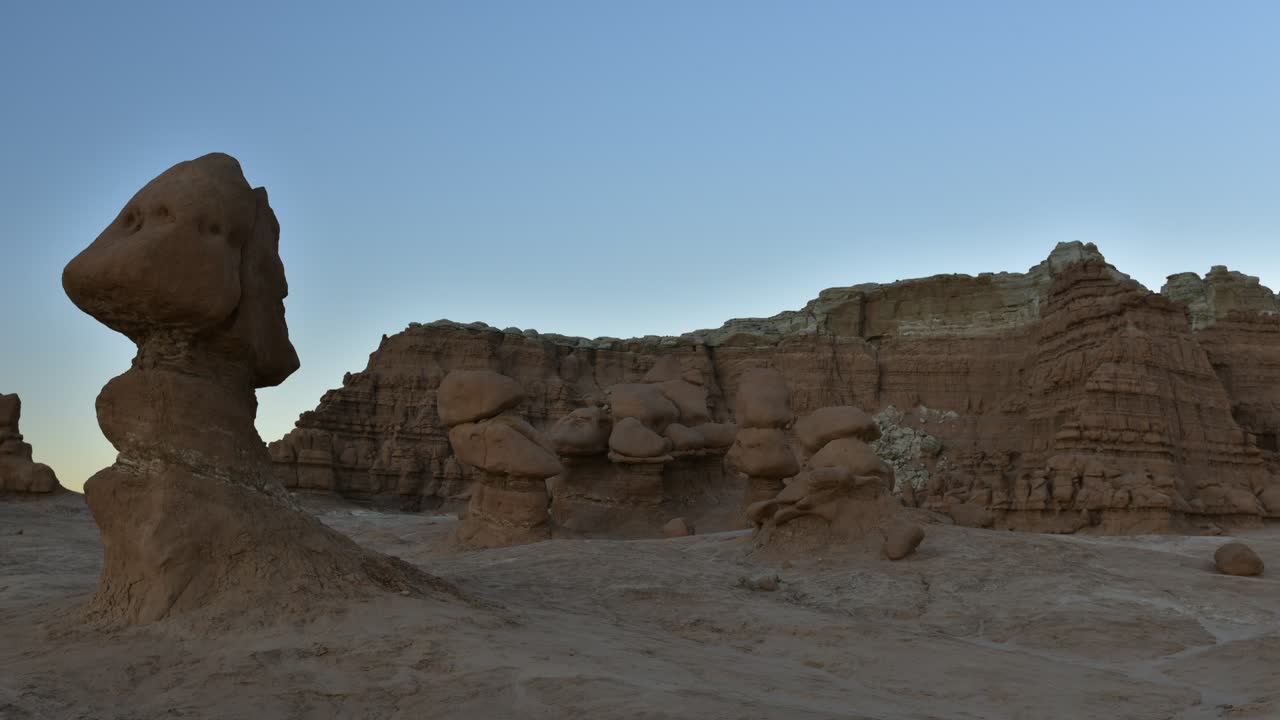 Shadows creep across the valley floor as the sun sets on the surreal landscape of sandstone hoodoos in the high southwest desert - time lapse - Goblin Valley State Park, Utah