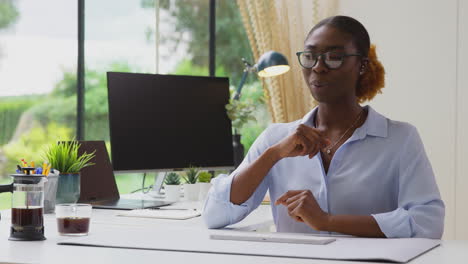 Woman-Working-From-Home-Office-At-Desk-Interacting-with-AR-Technology-Hosting-Virtual-Online-Meeting