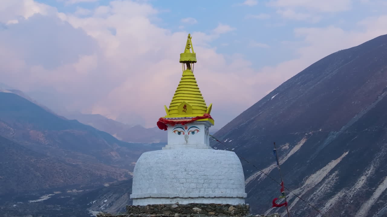 Aerial view of Dingboche Stupa enroute to Everest Base Camp, Buddhist flag flows in wind, dreamy clouds and Himalayan peaks in the backdrop Nepal
