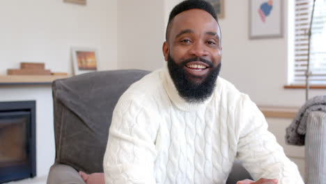 portrait of happy african american man in bright living room, slow motion