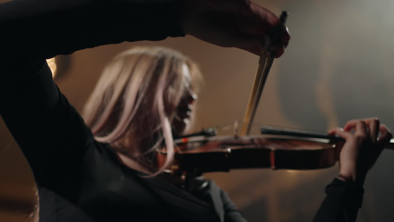 una mujer bonita con un violín rojo está tocando una melodía clásica en la escena del music hall.