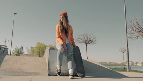 skater girl waiting for someone sitting on a skate park 2