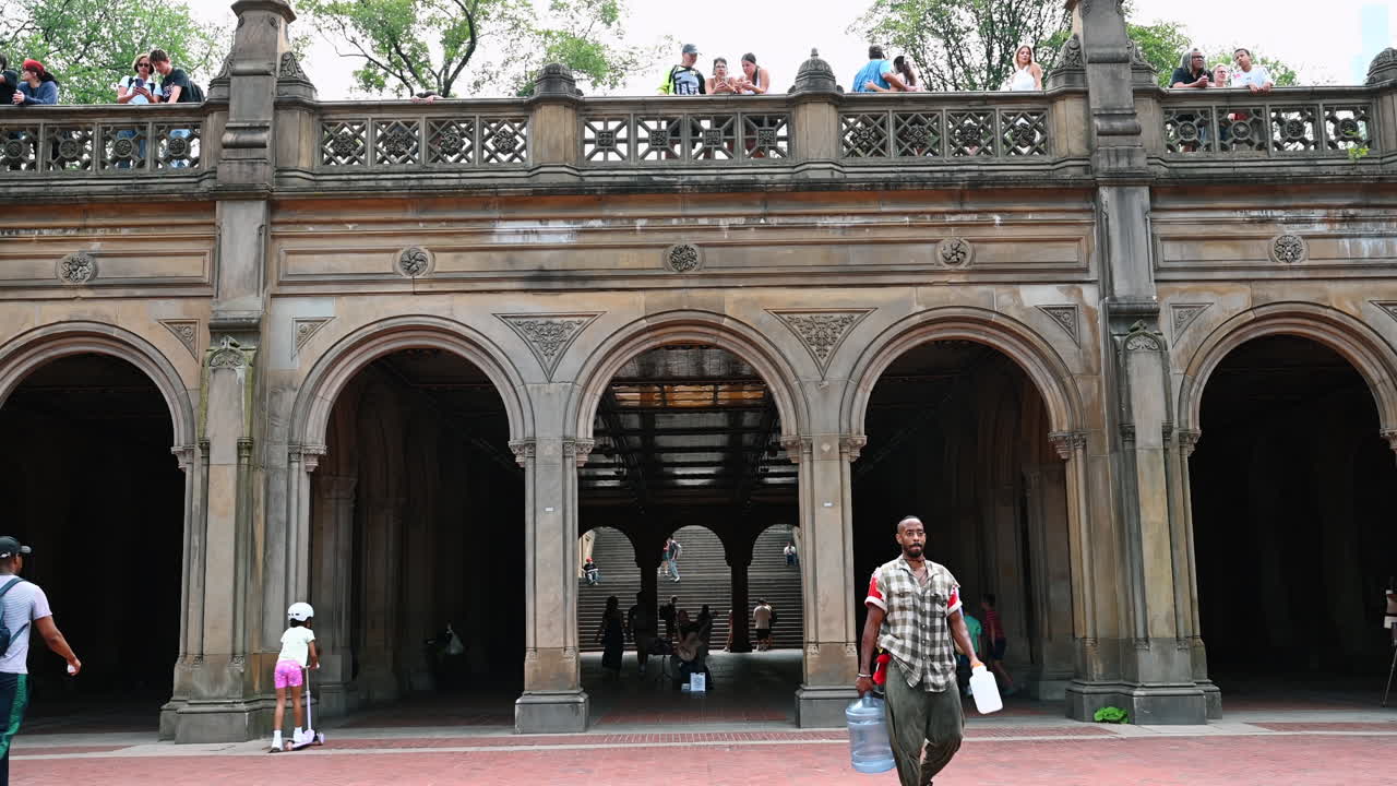 New York, USA, 8 July 2025: Summer stroll in Central Park. Visitors enjoy a vibrant summer day as they stroll through Central Park's iconic arches