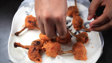 chef warping alluminium foil on fried crispy chicken lollipop, indian homemade fast food