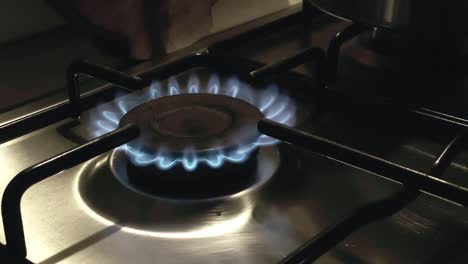 a gas stove ignites with a blue flame