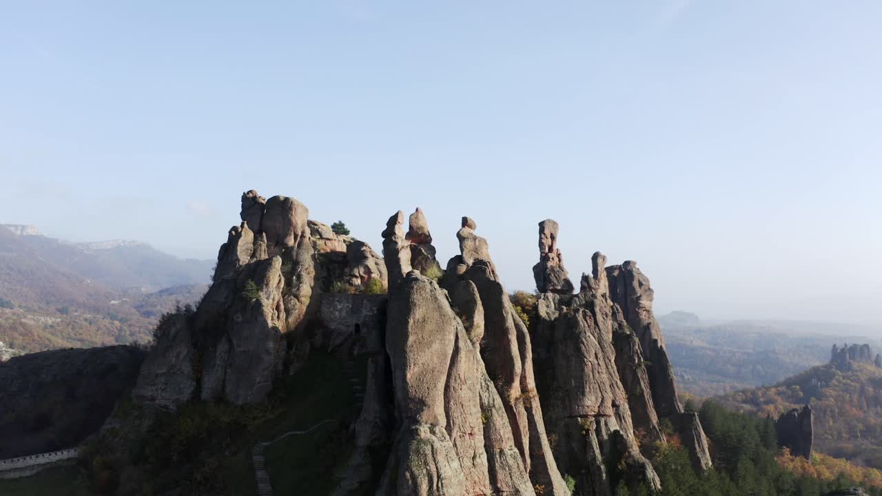 panorámica de izquierda a derecha de una toma aérea de drones de las rocas de belogradchik, una formación rocosa escultórica natural en la provincia de vidin en las estribaciones de la cordillera de los balcanes occidentales, bulgaria