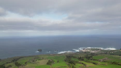 Hermosa-Costa-Del-Océano,-Pasto-Verde,-Aguas-Tranquilas,-Dron-Aéreo