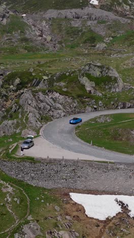 epic aerial view of the winding tremola road snaking through the alpine slopes of gotthard pass, switzerland, under a clear summer sky.
