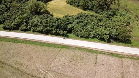 Vista-Aérea-De-Drones-De-4K-De-Una-Pareja-Montando-En-Motocicleta-En-El-Nido,-Palawan,-Filipinas