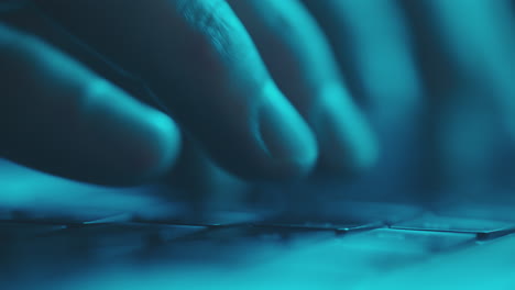 hands typing on a laptop keyboard at night