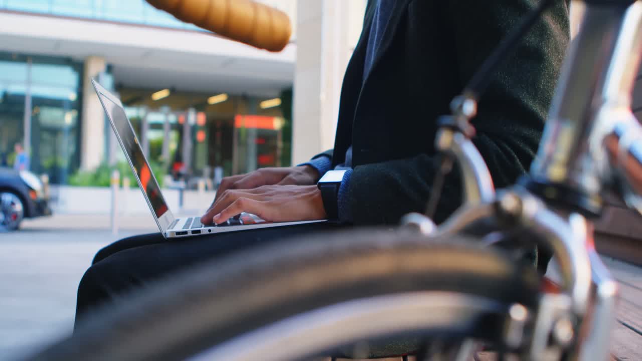 Man sitting on bench and using laptop 4k