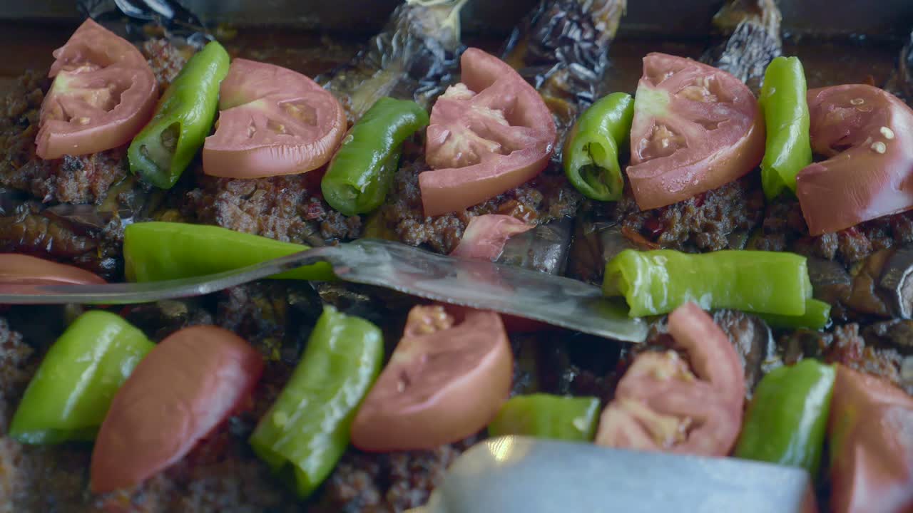 Primer plano de un plato tradicional de berenjenas rellenas con tomates y pimientos