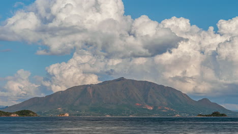 The-famous-mountain-peak,-Mont-Dore-in-New-Caledonia-as-seen-from-across-the-bay-with-huge-cumulus-clouds-forming-and-dissipating-above-the-island---time-lapse