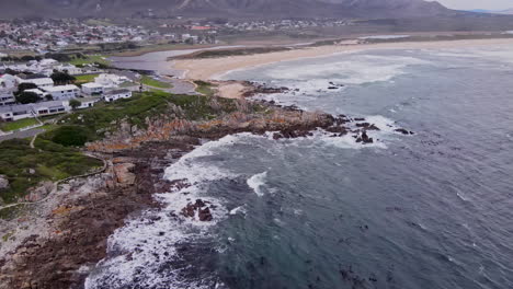 drone flight over kleinmond rugged rocky coastline toward lagoon and beach