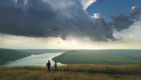 the young couple jogging on the beautiful river background. slow motion