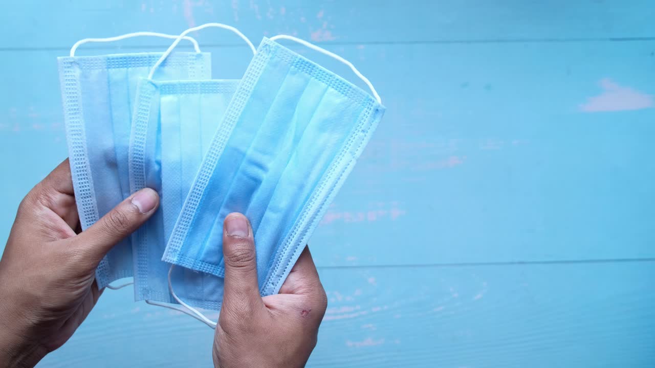 여러 개의 얼굴 마스크를 들고 있는 손