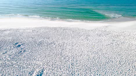 fly over the walking path on the white sand beach of pensacola beach to the clear emerald waters of the gulf of mexico on a clear sunny day