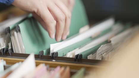 Businessman searching for documents in the office filing cabinet