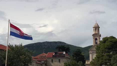 croatian flag flying with kaštel lukšić in the background