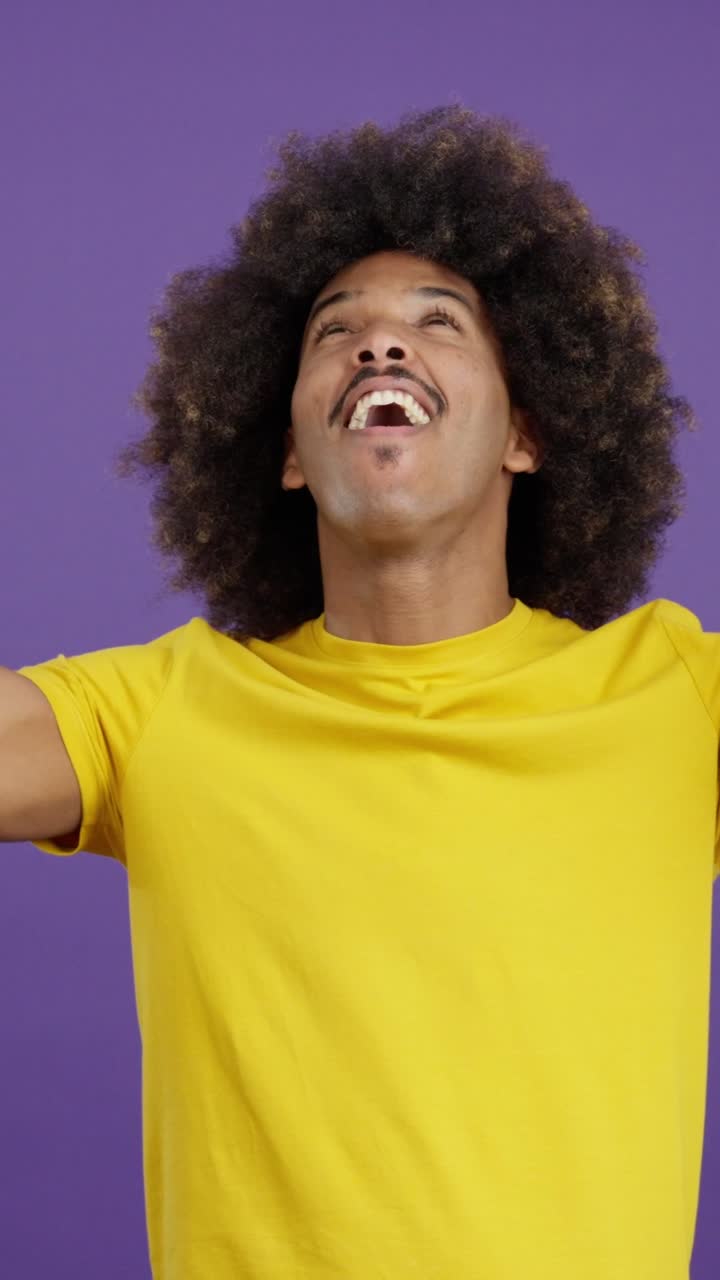 A man with an afro displaying various expressive and happy emotions