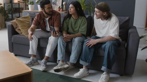 friends socializing and sharing on a smartphone in a living room