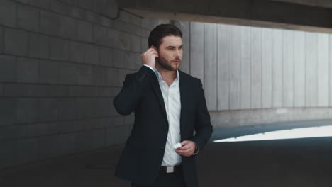 Business-man-opening-box-with-earbuds-on-street.-Manager-putting-on-earphones
