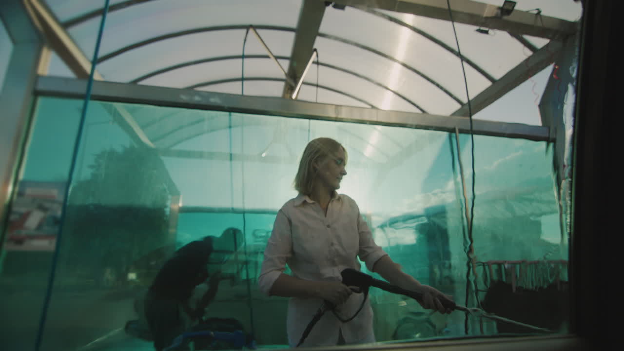 женщина моет машину на мойке самообслуживания 1