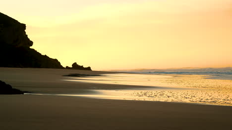 Sanftes-Goldenes-Licht-Bei-Sonnenaufgang-über-Dem-Unberührten-Strand,-Nasse-Sandreflexion