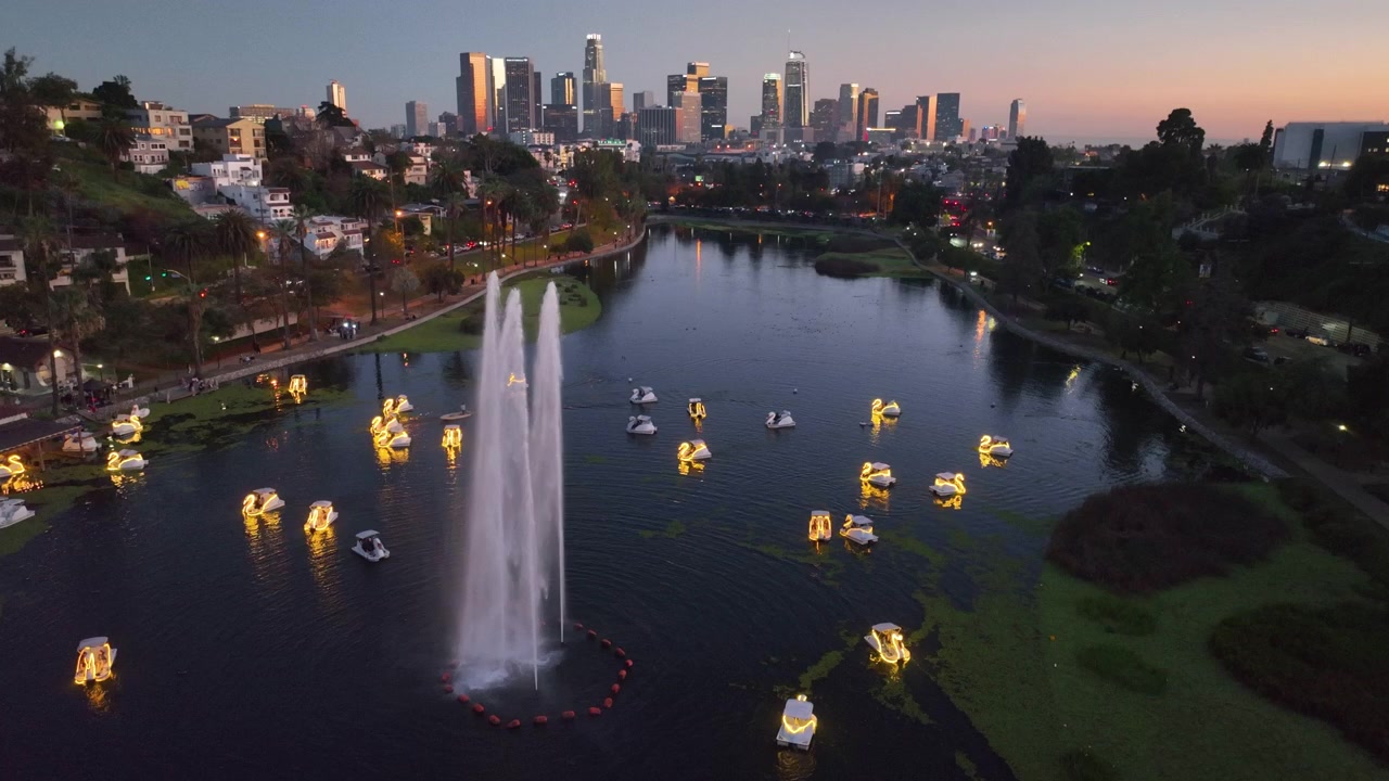 Vista aerea in lenta ascesa di cigni al lago Echo Park e dello skyline del centro di Los Angeles.