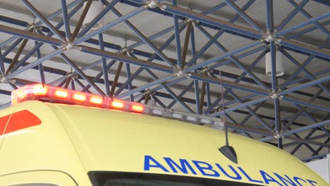 Close-up-of-the-top-of-a-yellow-ambulance-with-it's-flashing-lights