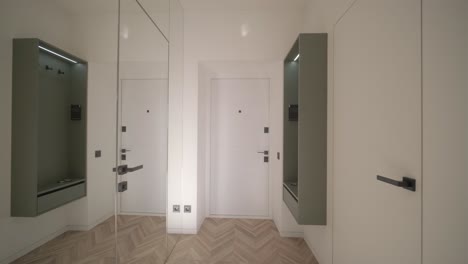 white closed doors in light corridor in stylish modern apartment with a mirror