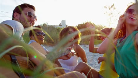 amigos multiétnicos tocando la guitarra y disfrutando de un picnic
