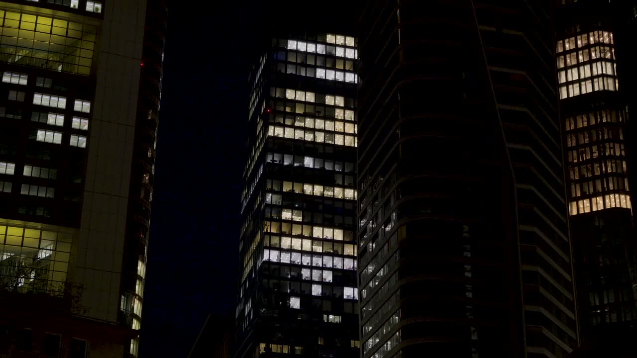 Night view of illuminated office buildings in Frankfurt, Germany with lit windows