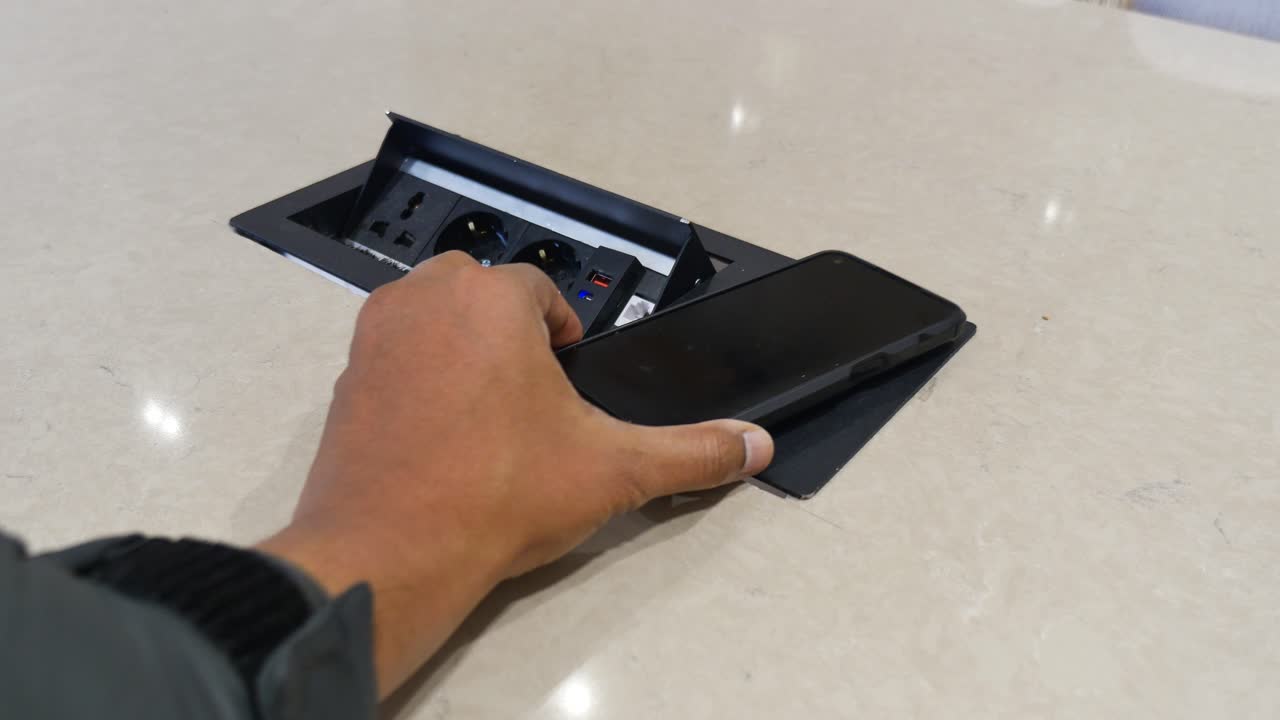 Stikkontakt og telefon på bordet